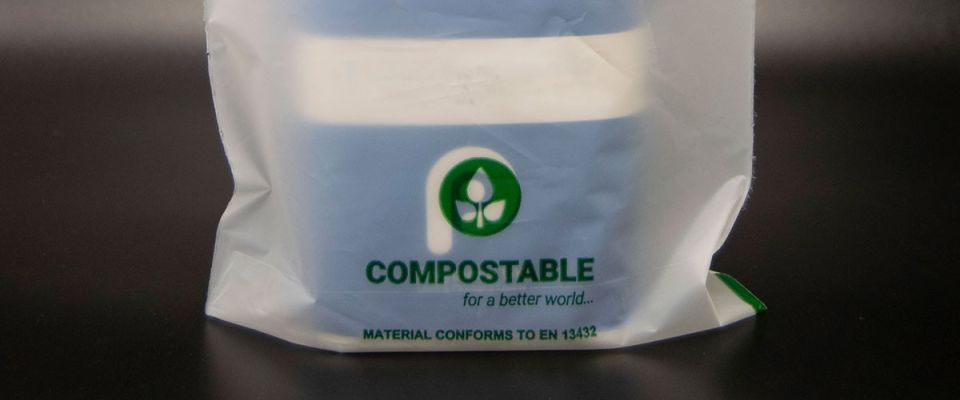 young lady picking up litter and placing it in a polythene bag
